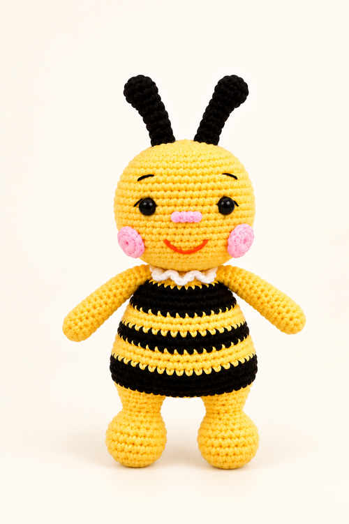Yellow and black handmade crochet bee charm on a cream background