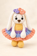 White crochet gift doll in a colorful floral dress on a cream background